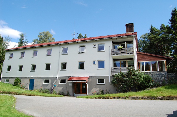 En stor hvit bygning med rødt tak