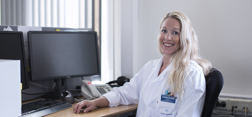 Kvinnelig ansatt i uniform foran PC. Foto