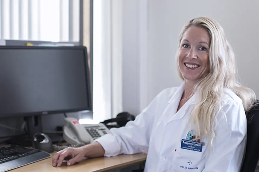 Kvinnelig ansatt i uniform foran PC. Foto