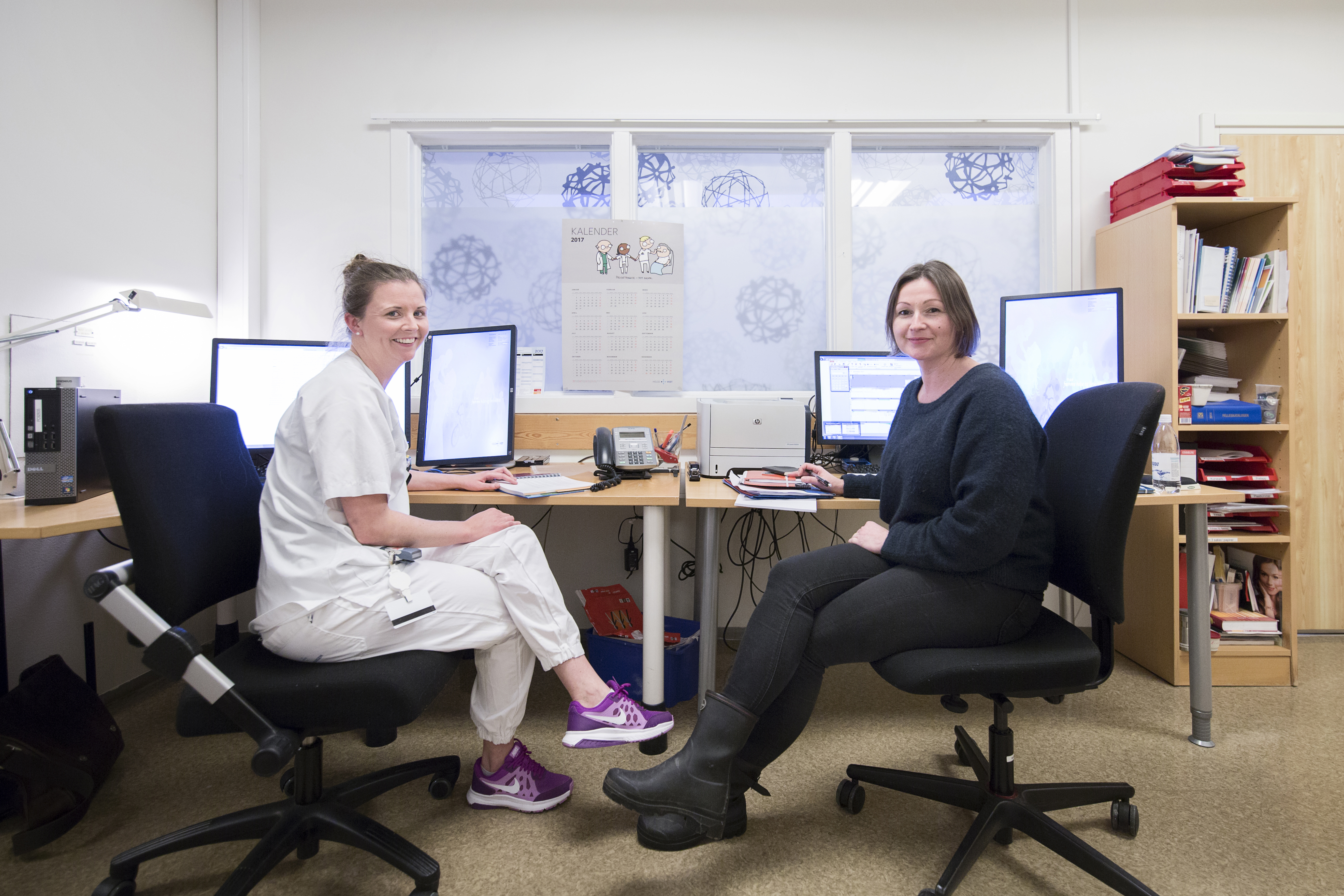 to ansatte foran pc-skjermer