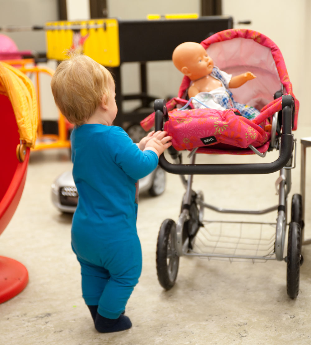 Foto. Et barn som kjører en dukkevogn