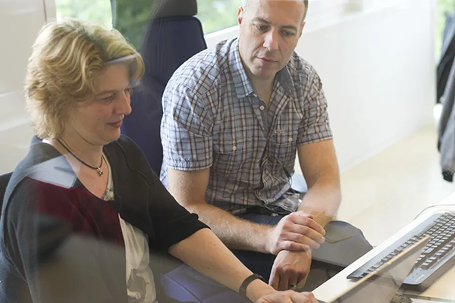 A man and a woman looking at a computer screen