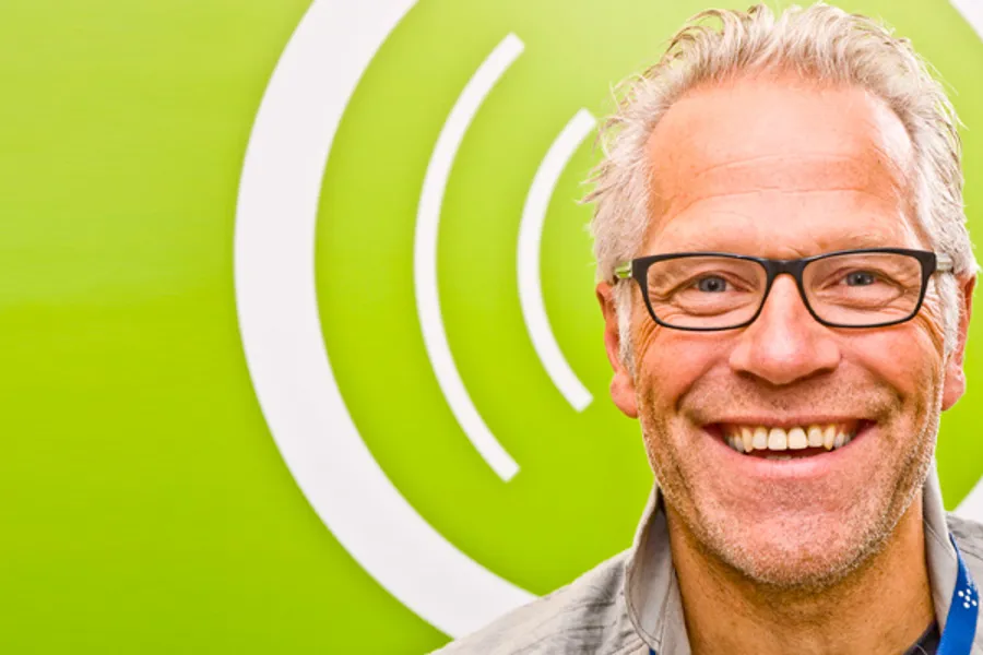 En mann med briller som smiler