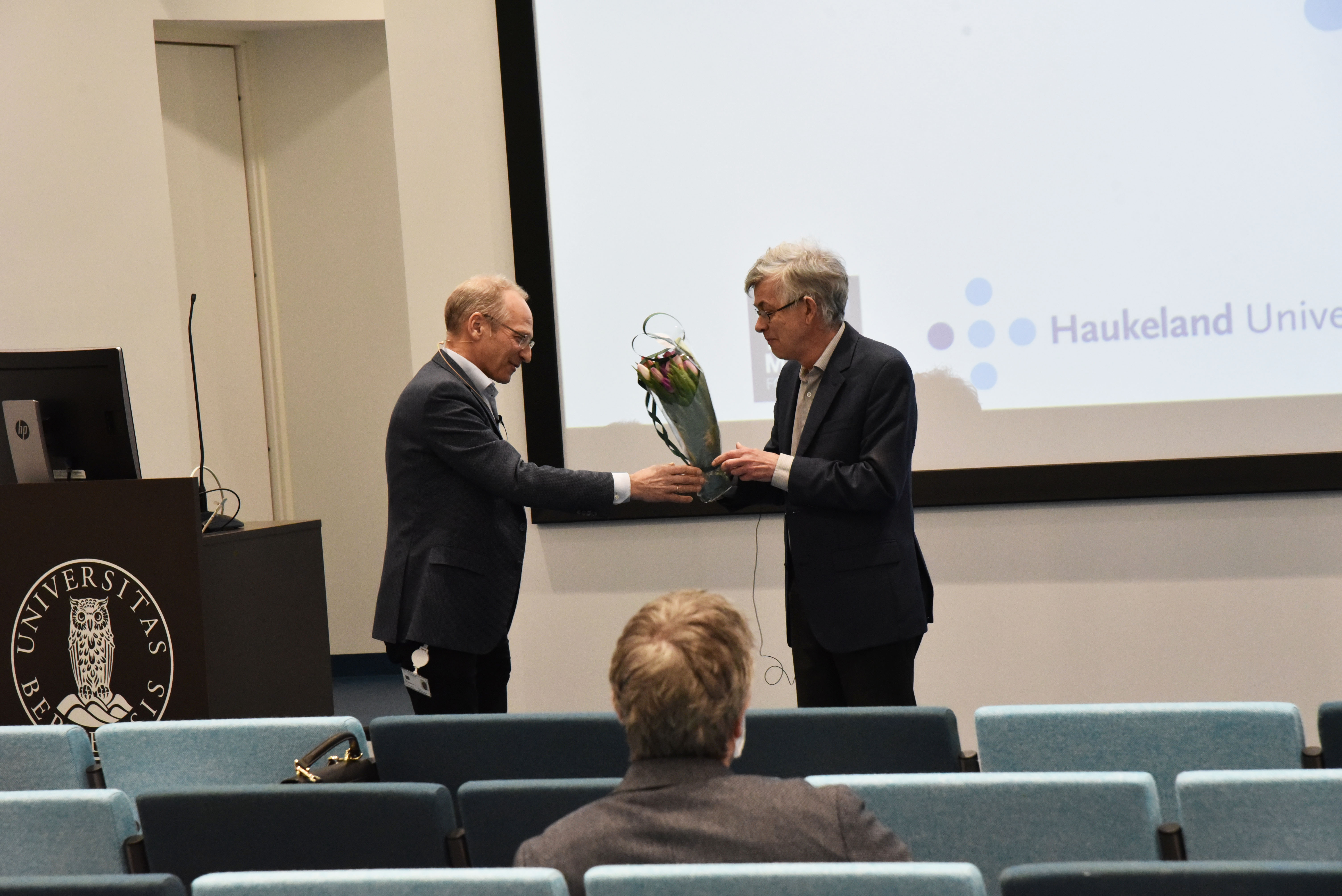 Foredragsholder får blomster. Foto