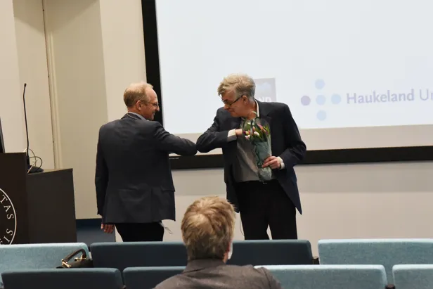 Foredragsholder hilser med albuen. Foto