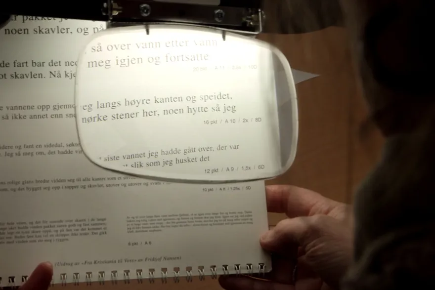 tekst ses gjennom forstørrelsesglass