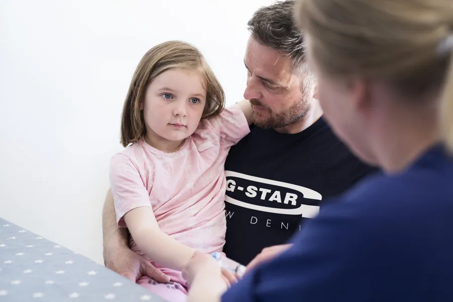 bilde: jente på arment til far snakker med sykepleier