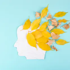 Illustrasjon med papirklipp av et hode med høstløv som blåser ut av hodet.