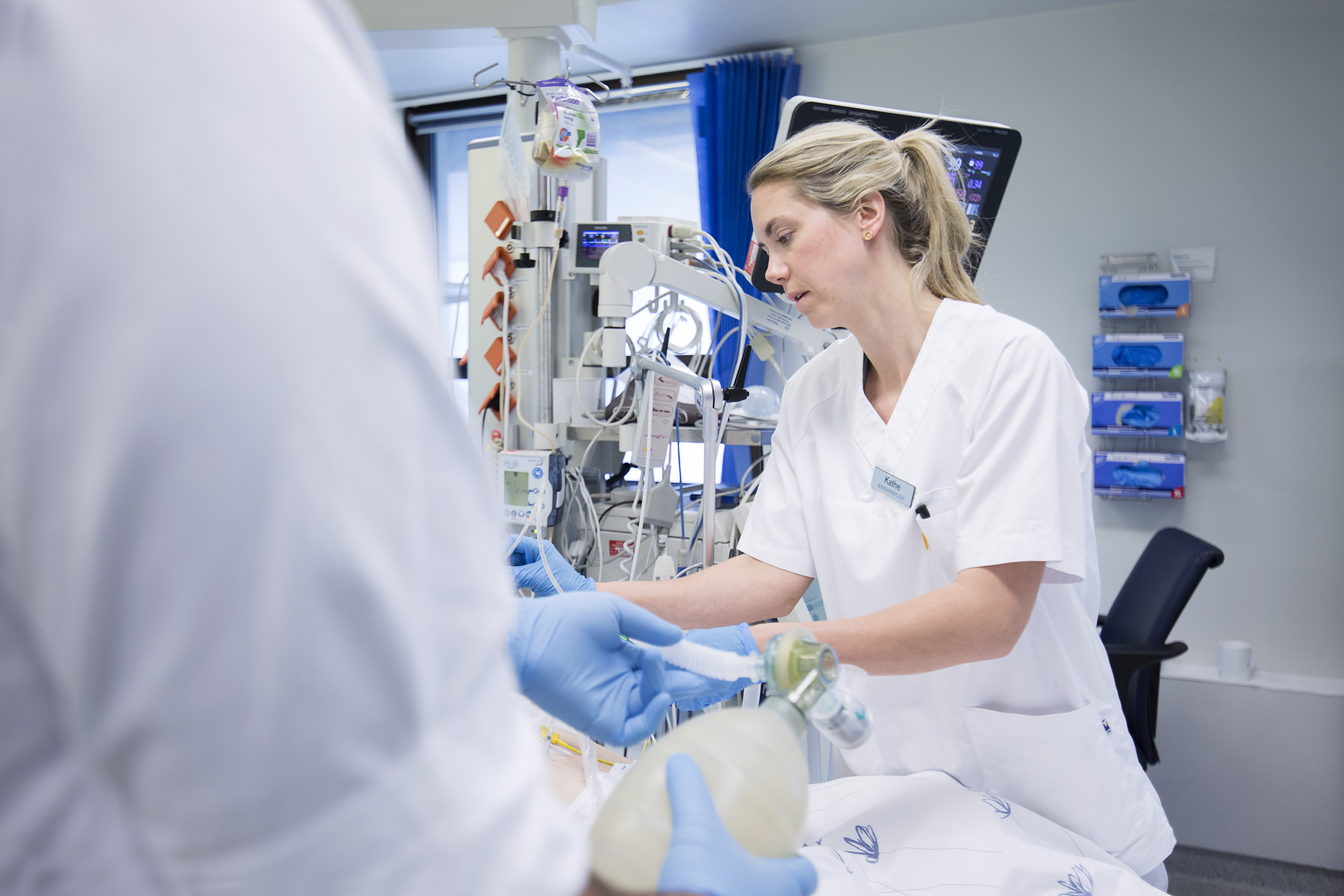 Hender med hansker inntuberer pasient. Foto