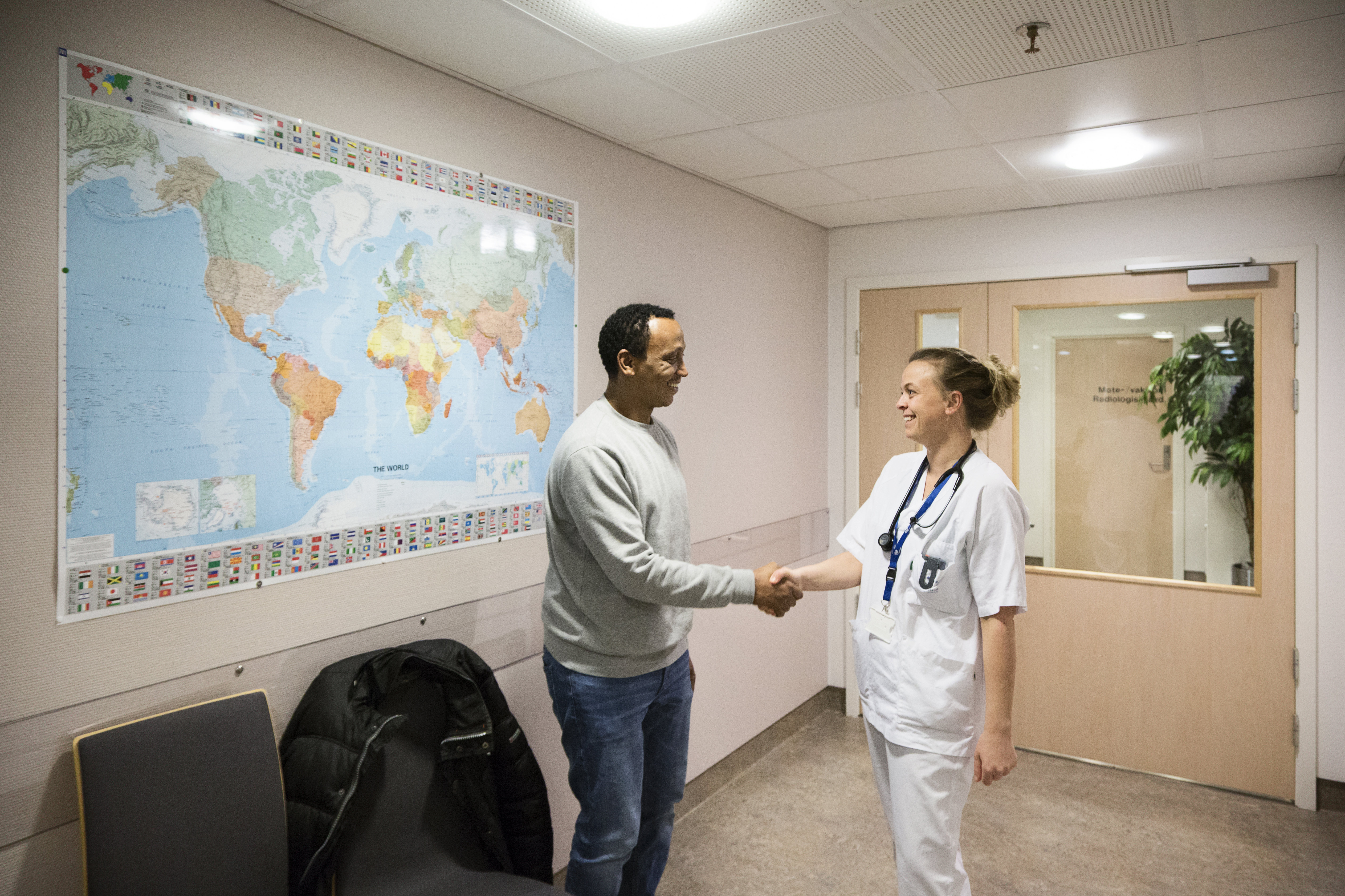 Mannlig pasient håndhilser på lege. Foto