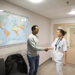 Mannlig pasient håndhilser på lege. Foto