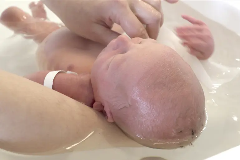 En person som vasker en babys hode