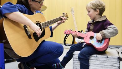 musikkterapeut og gutt spiller på hver sin gitar
