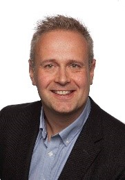 En mann som smiler til kameraet