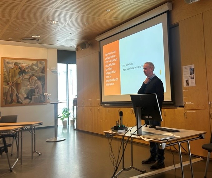 En person som står foran en projektorskjerm