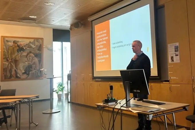 En person som står foran en projektorskjerm