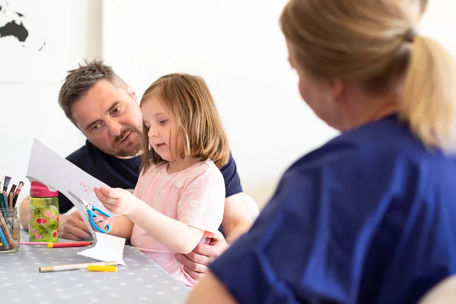 Bilde: barn og voksen får informasjon av helsepersonell