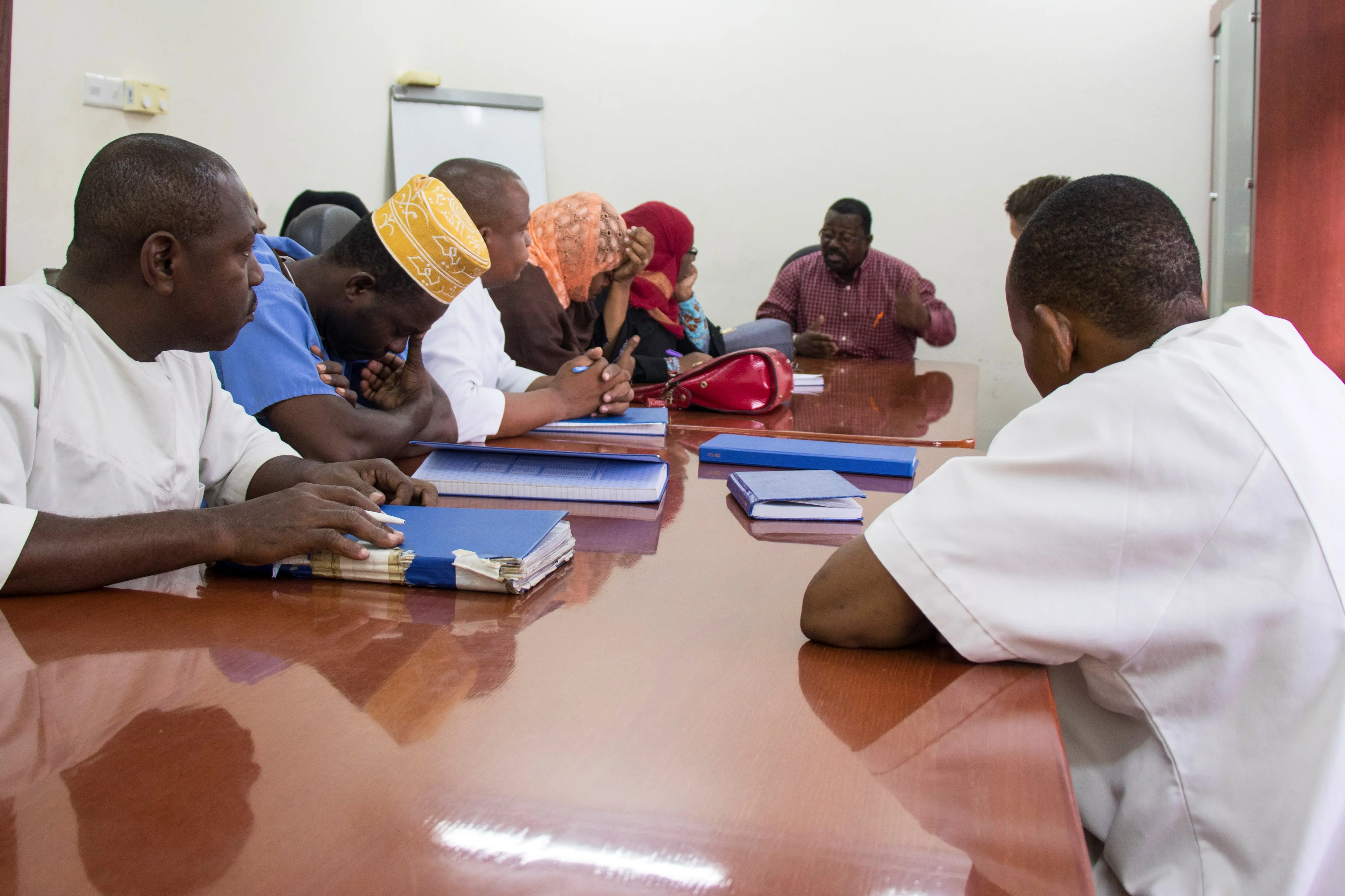 mange mennesker rundt et møtebord
