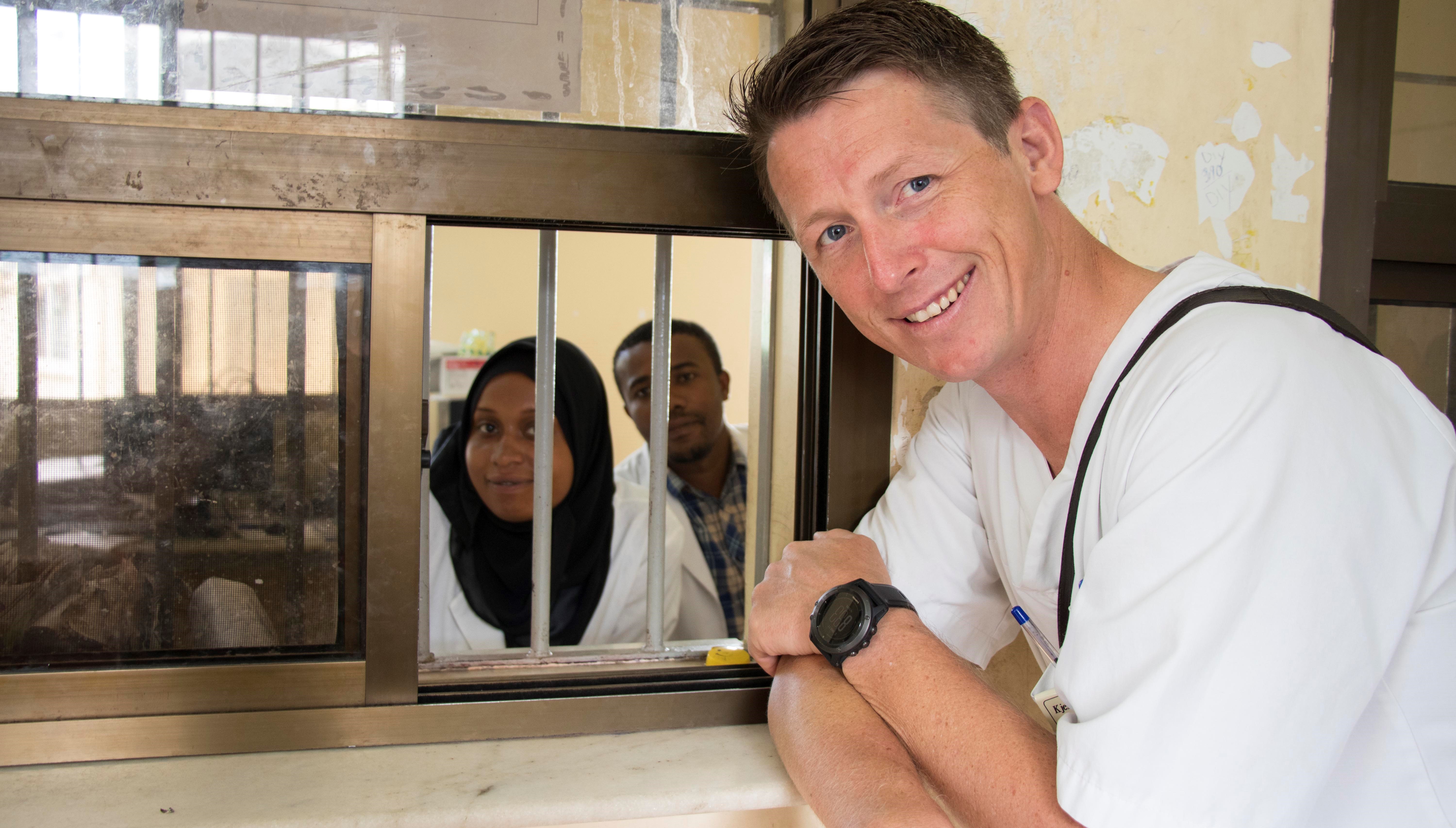 sykepleier står foran luka og snakker med ansatte 