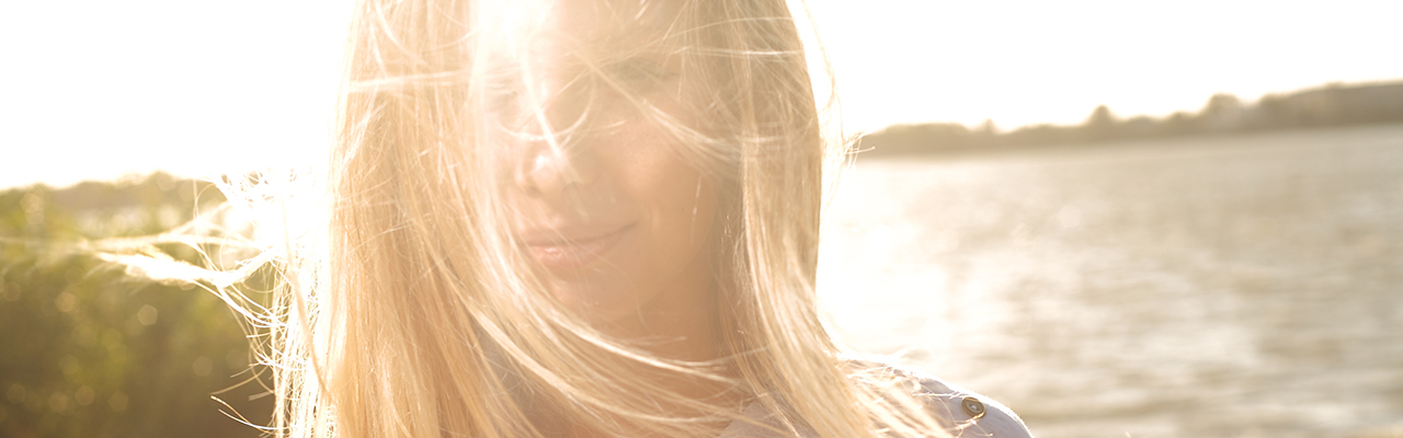 Kvinne med solen bak seg. Foto