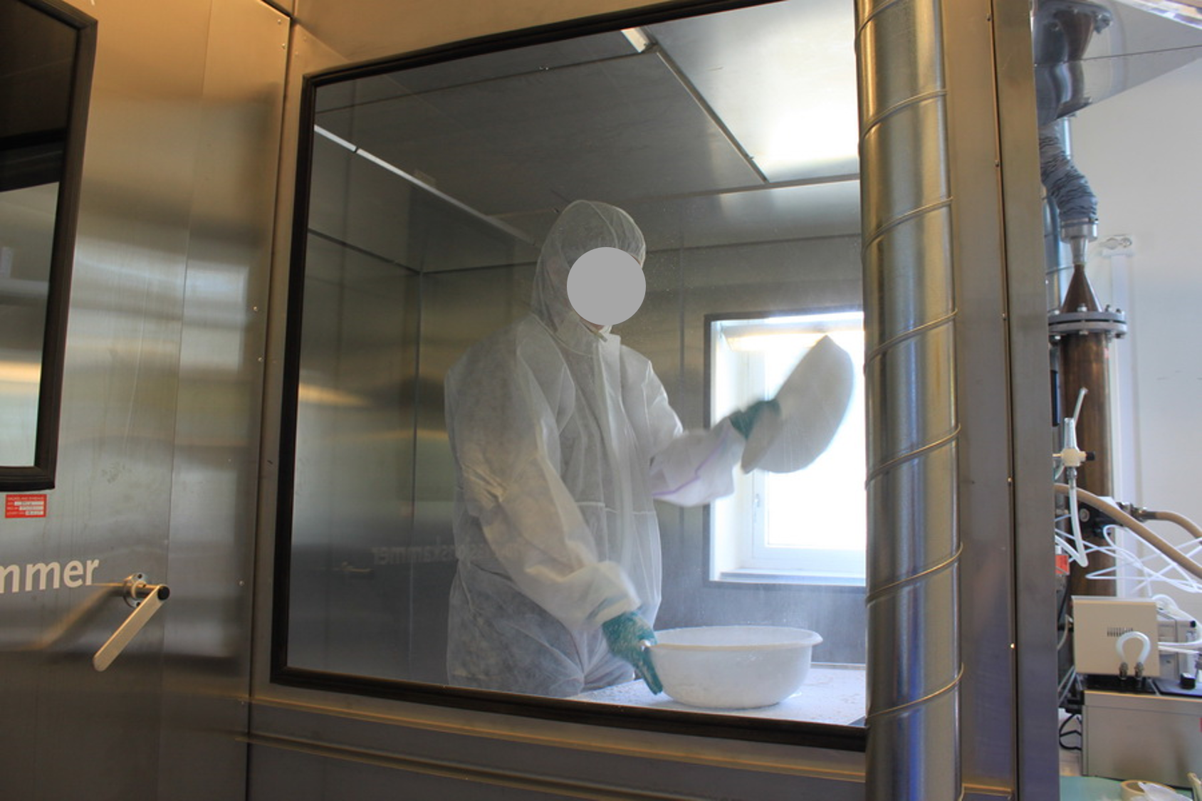 Ansatt i beskyttelsesutstyr i laboratorium. Foto