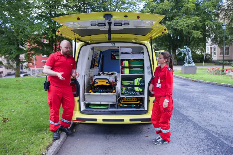 to ambulansearbeidere bak ambulanse. Foto.