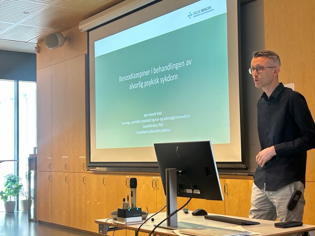 En mann som står foran et projektorlerret