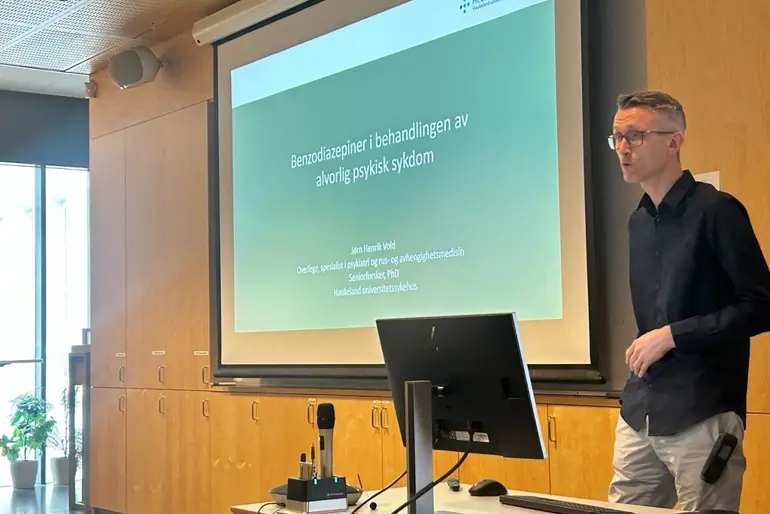 En mann som står foran et projektorlerret