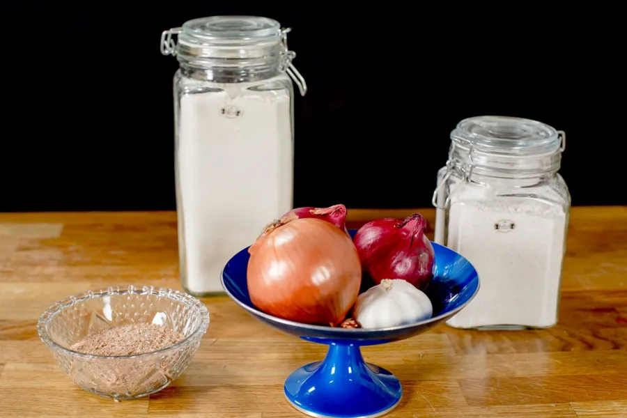 En bolle med frukt og en krukke mel på et bord
