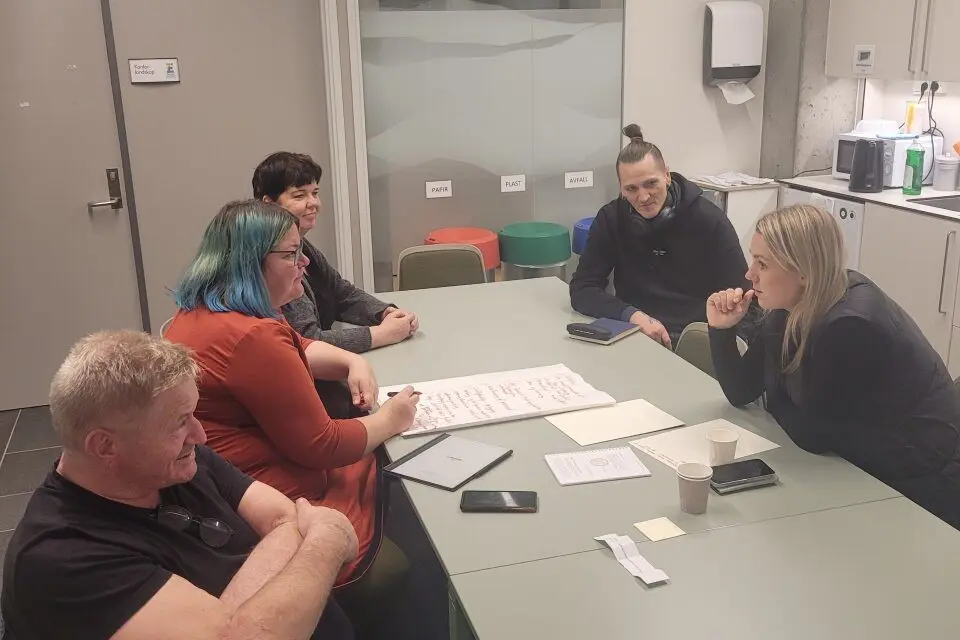 En gruppe mennesker som sitter rundt et bord