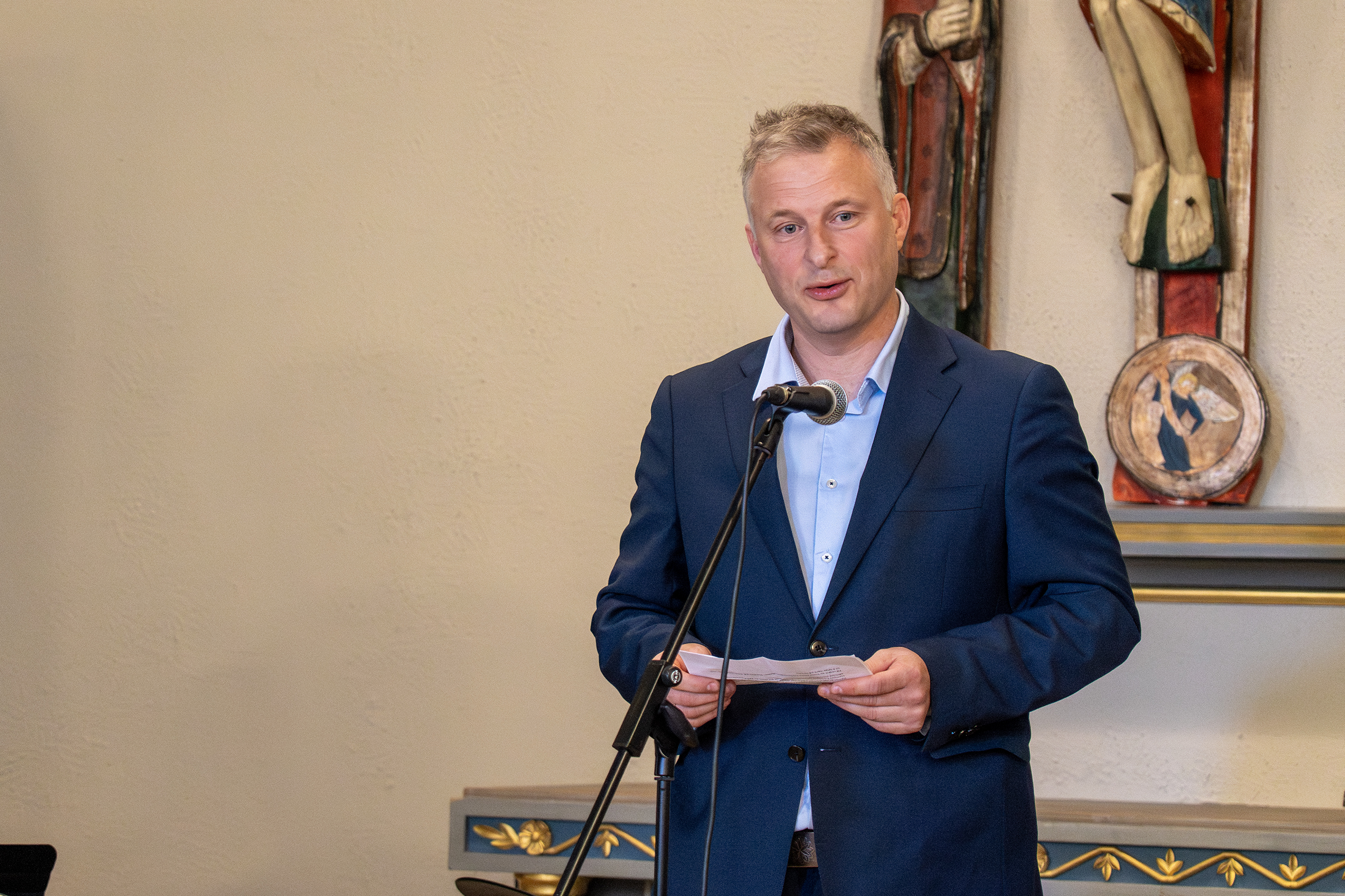 En person i dress som står ved et podium med en mikrofon