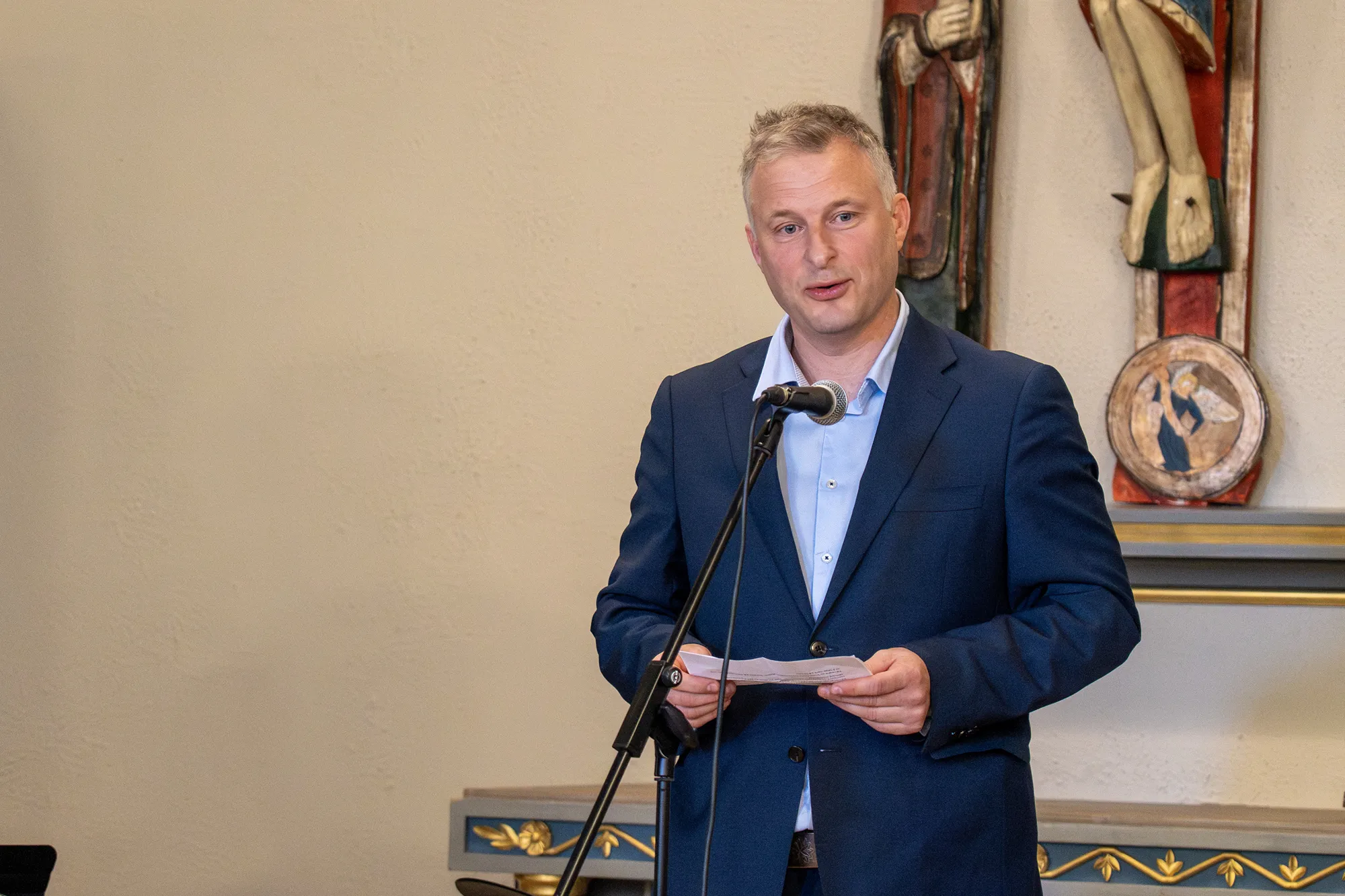 En person i dress som står ved et podium med en mikrofon