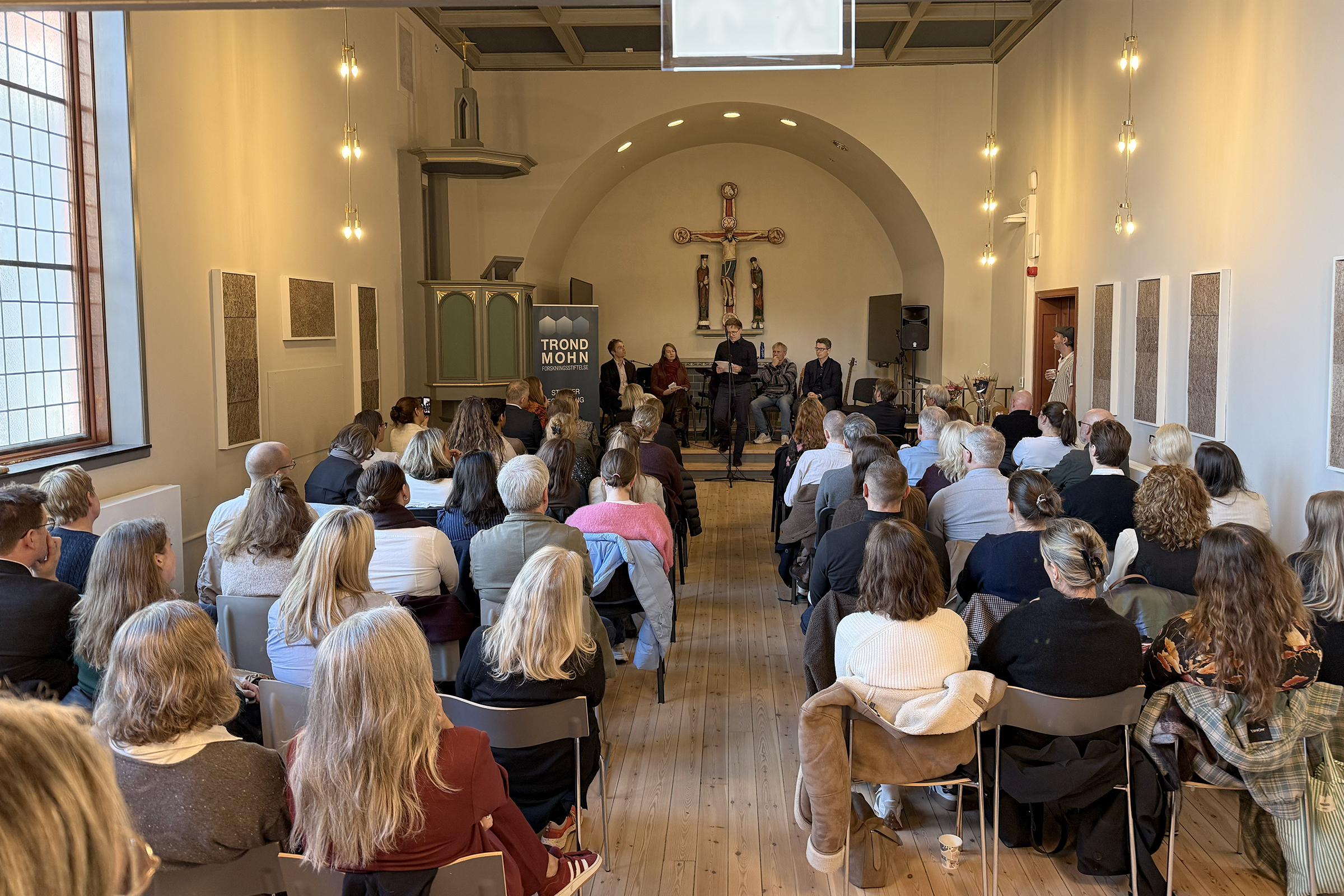 En gruppe mennesker som sitter i en kirke