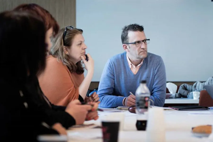 Gruppe menneske rundt møtebord.