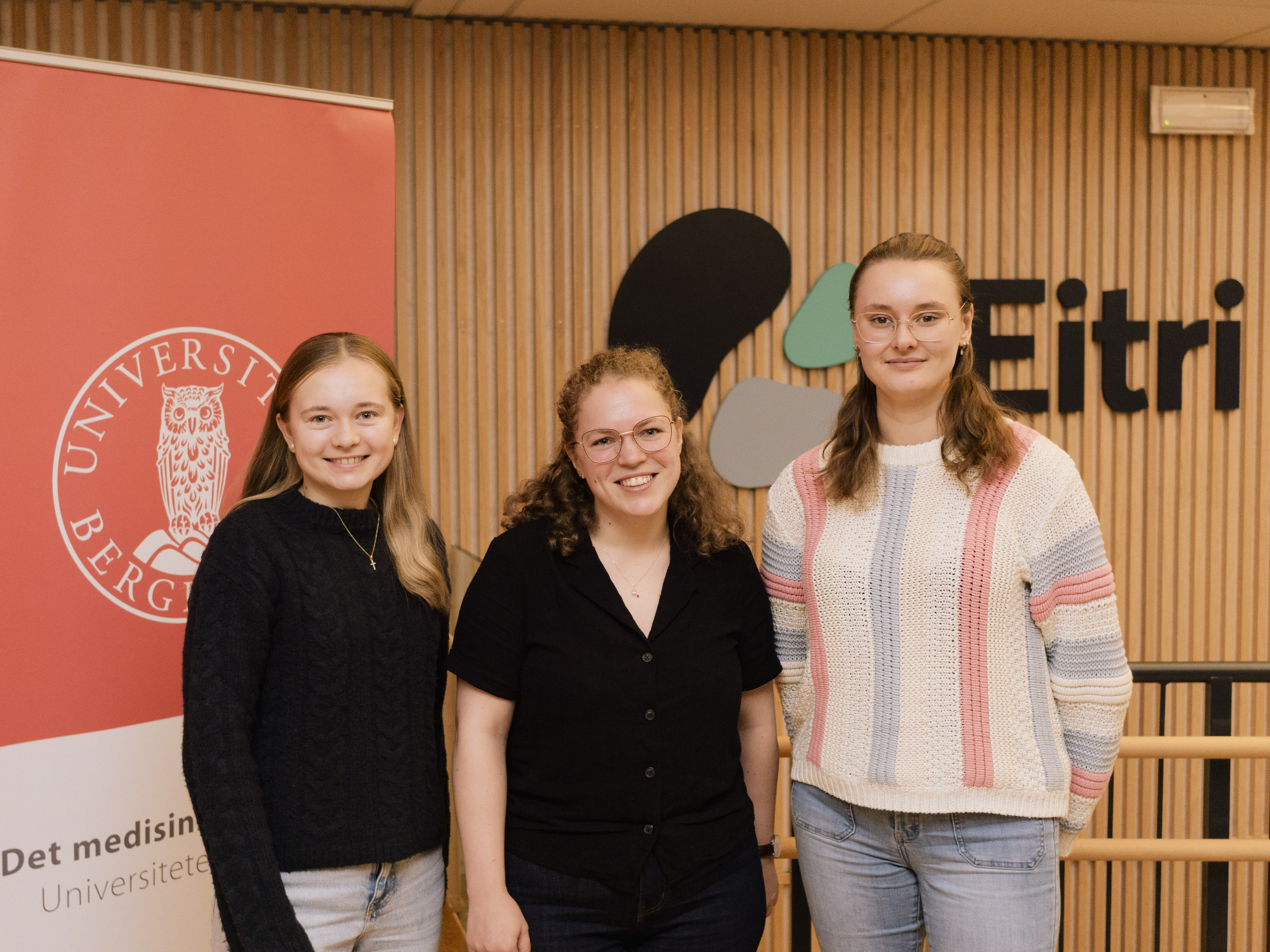 tre unge damer står og smiler