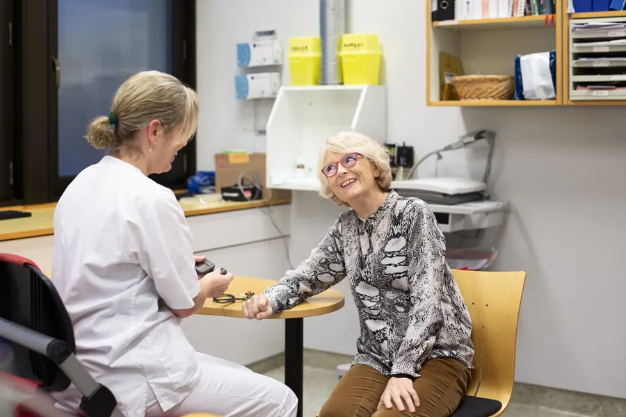 En person som sitter ved siden av en person i en stol