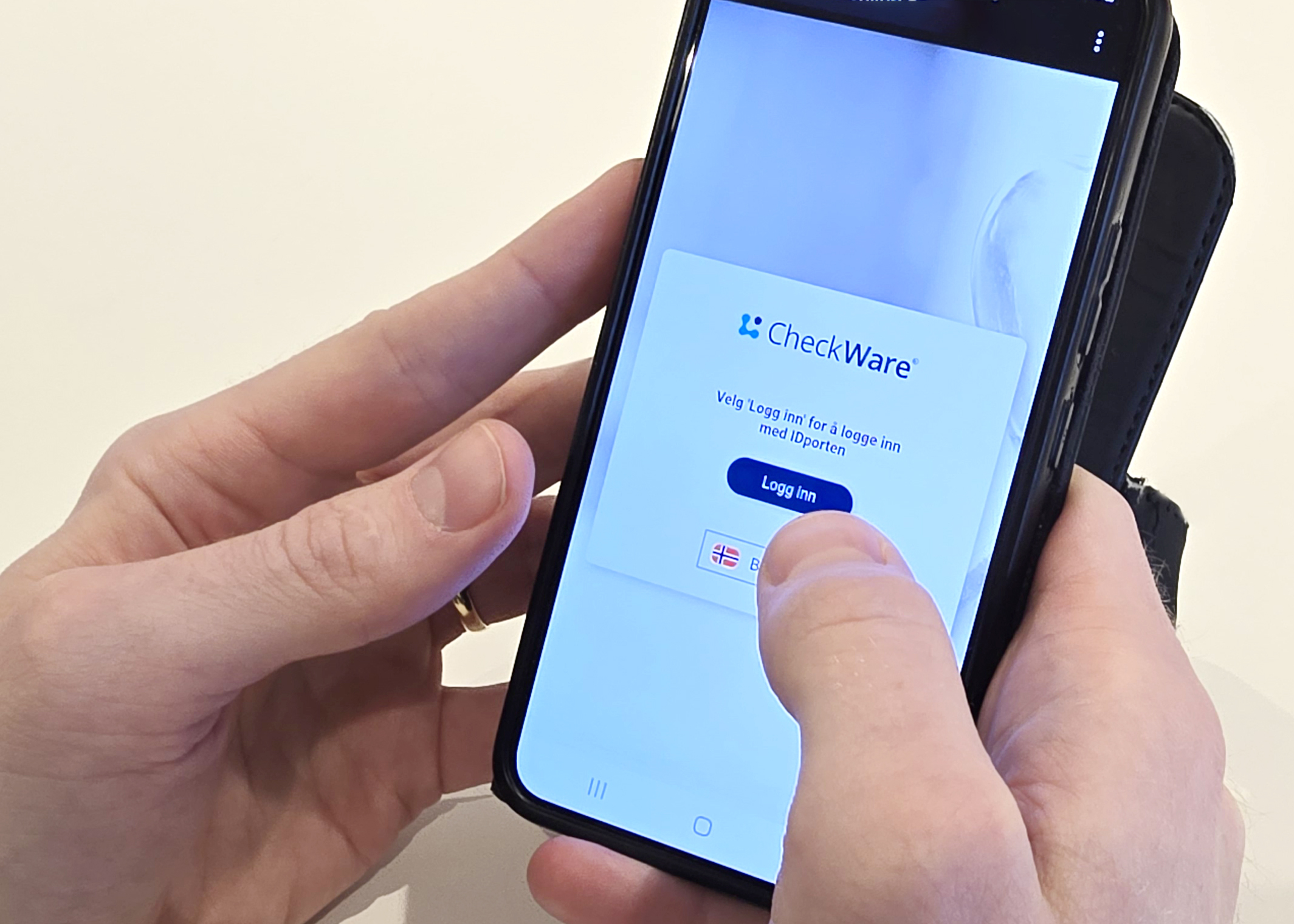 En hånd som holder en mobiltelefon