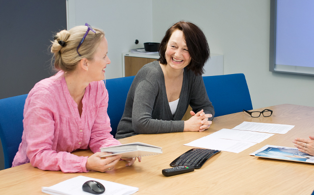 Tre kvinner samlet rundt møtebord. Foto