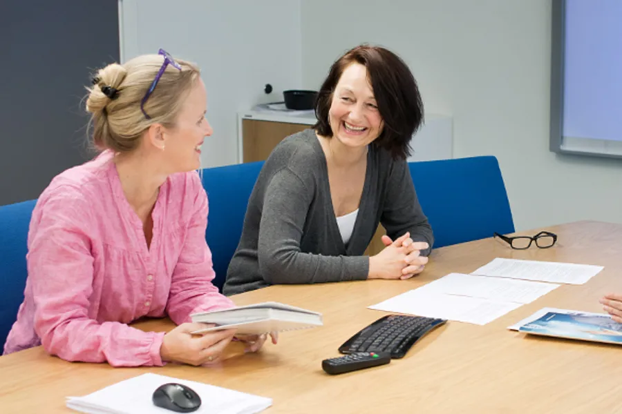 Tre kvinner samlet rundt møtebord. Foto