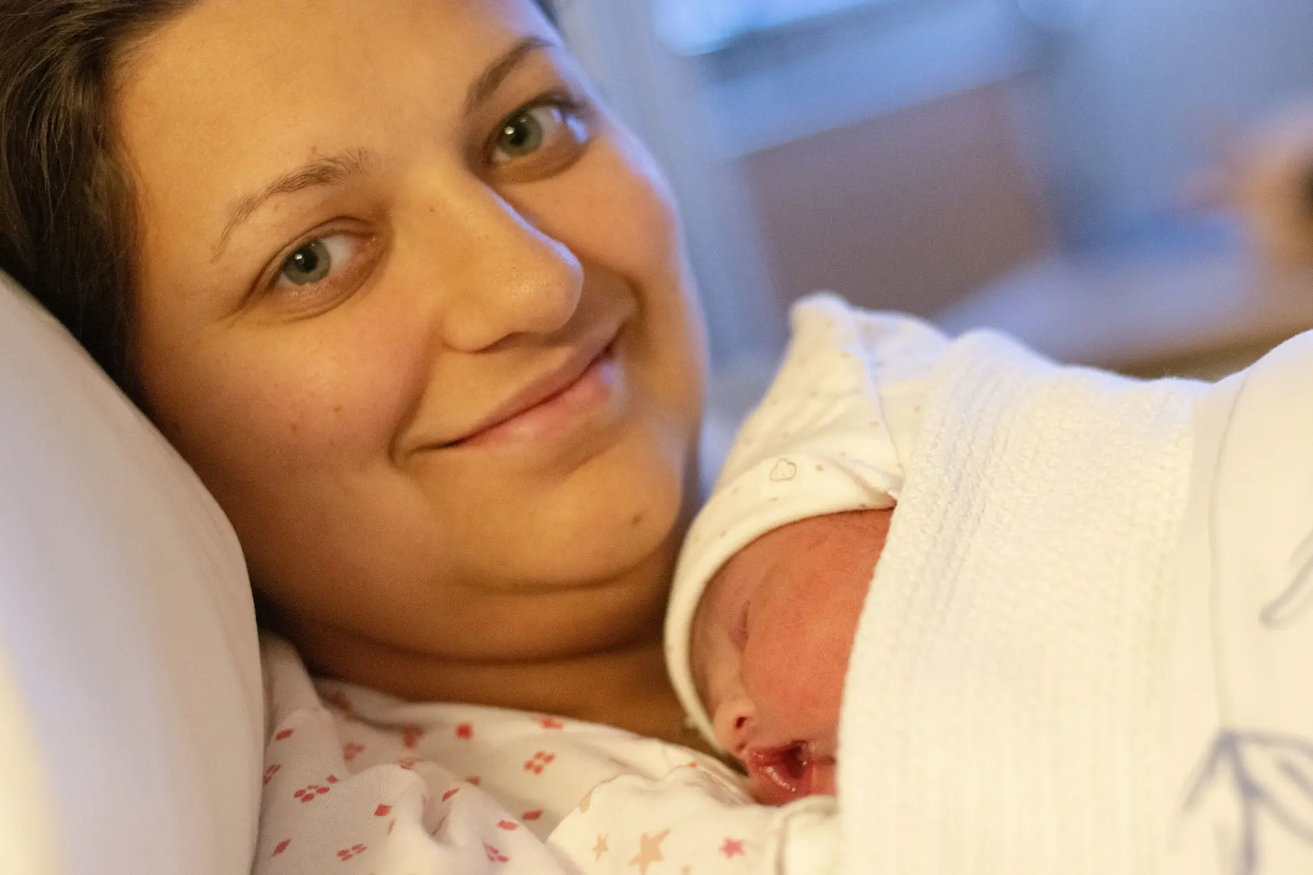 Kvinne med nyfødd på brystet.