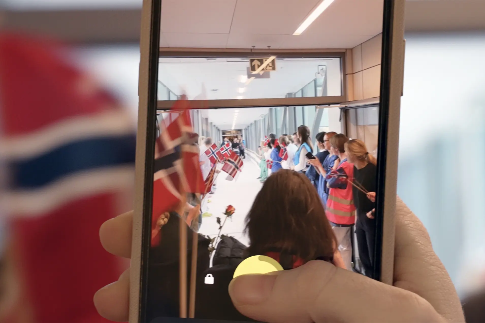 Bilde av ein skjermen til mobiltelefon som tar bilde av opptog og flagg.