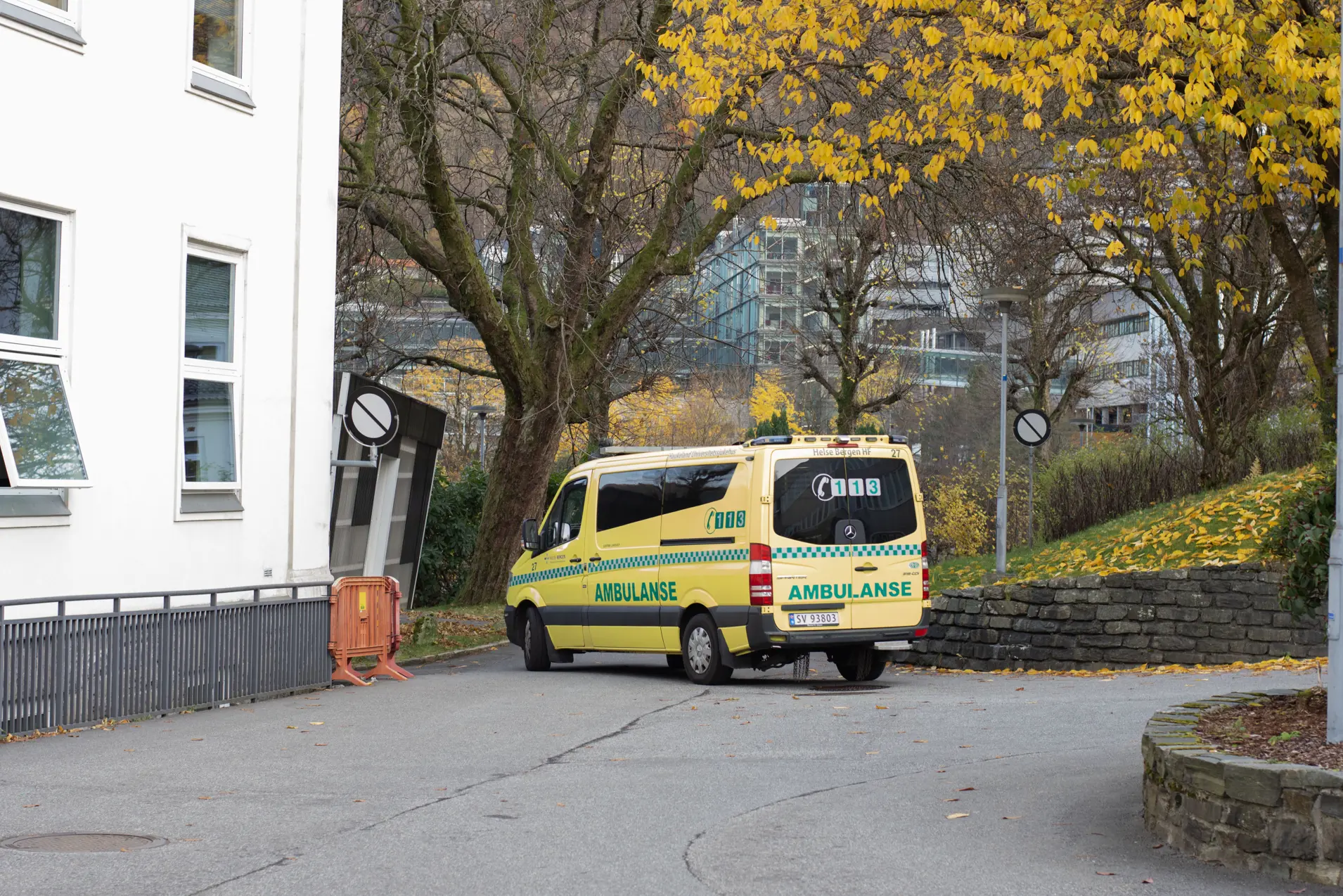 Ambulanse køyrer mot nye KK i Glablokkene, trær med gule bladar.