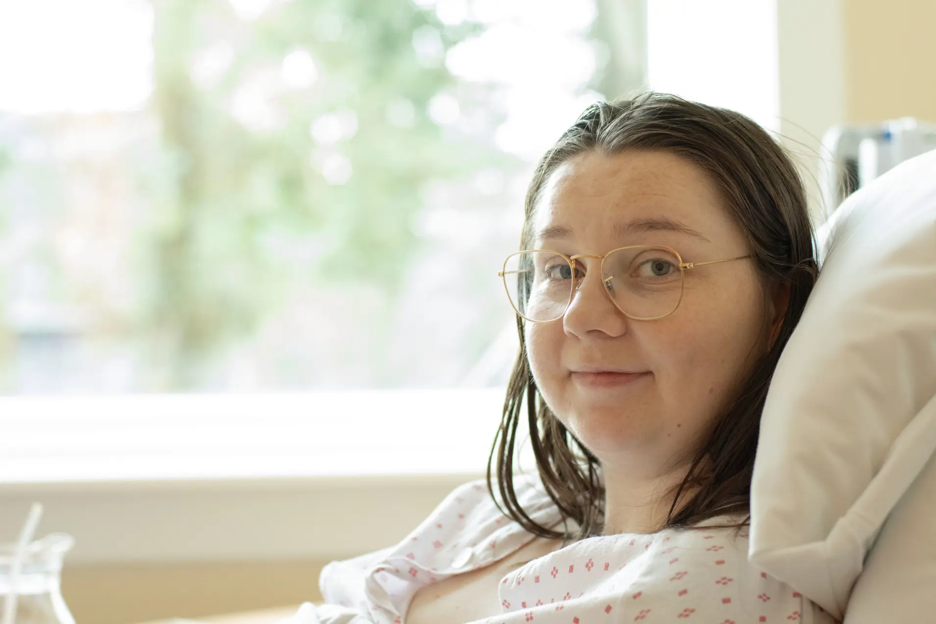 Kvinne i seng på rom på gamle Kvinneklinikken.