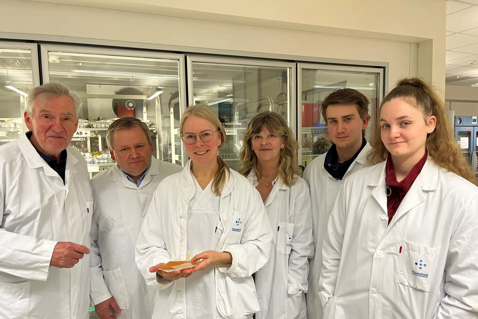 En gruppe mennesker iført hvite labfrakker