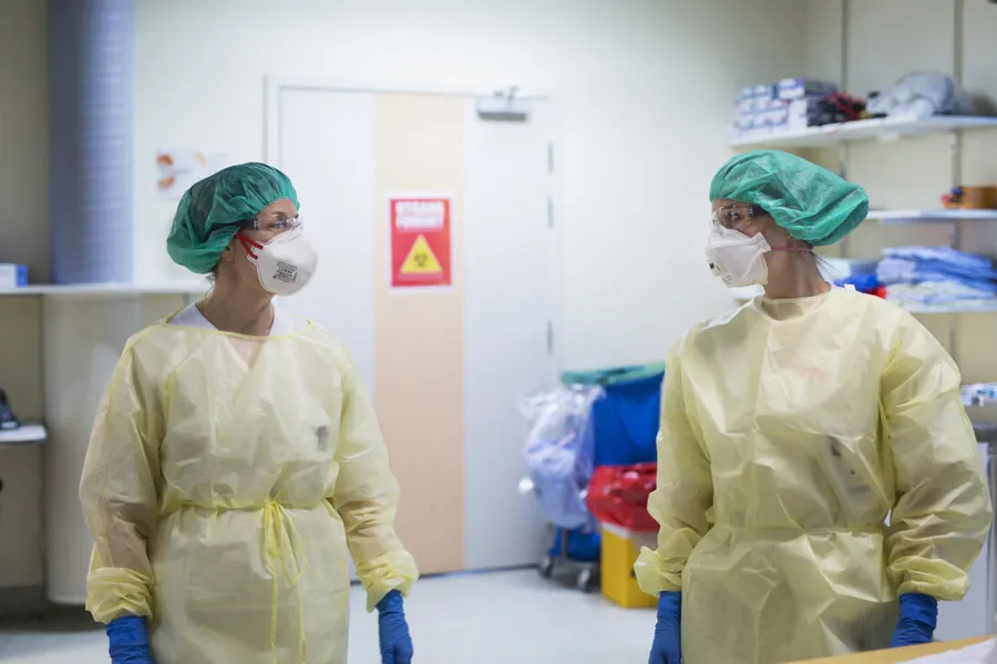 Et par personer iført kirurgiske skrubb og masker