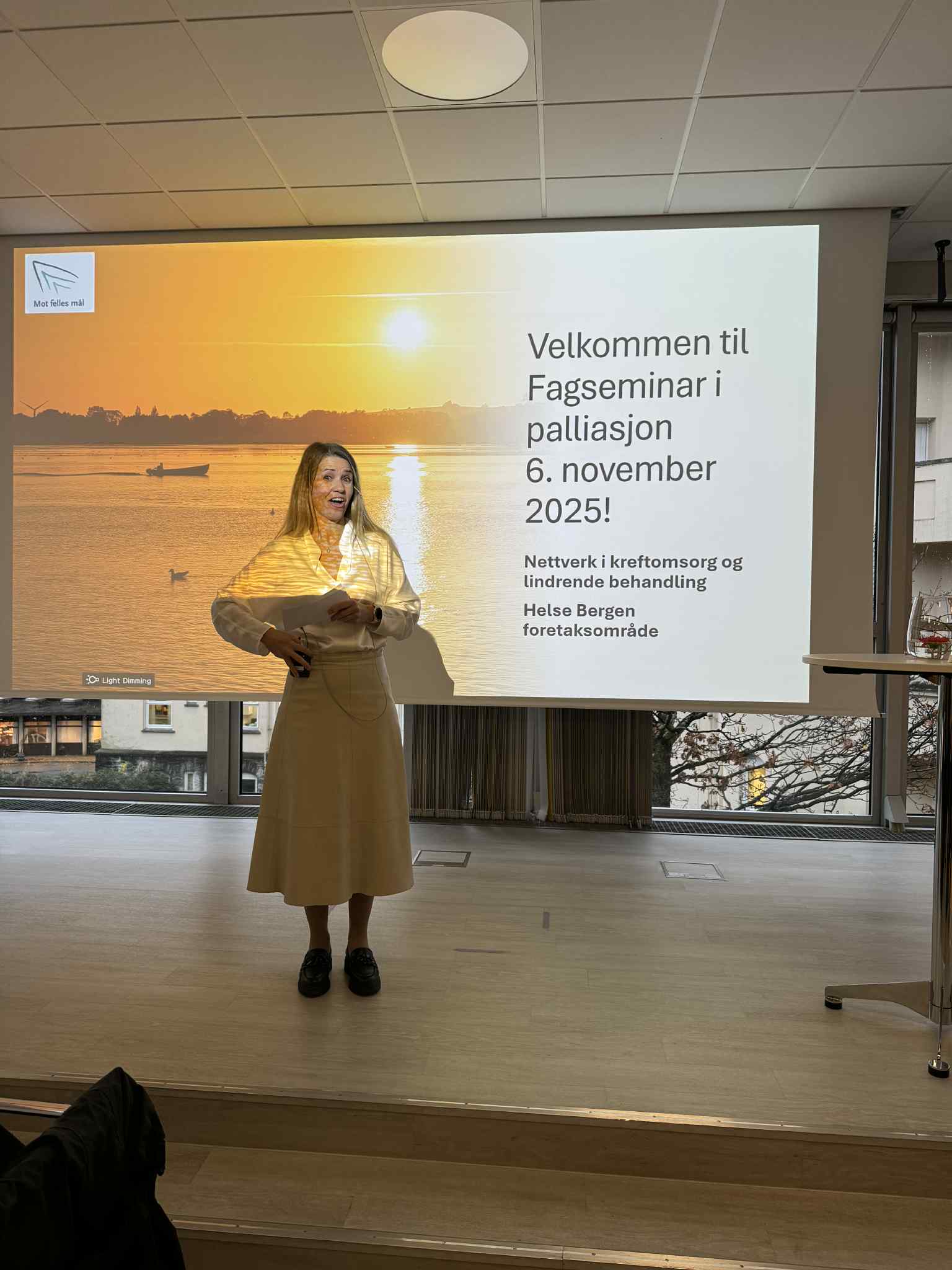 En person som står foran en stor skjerm