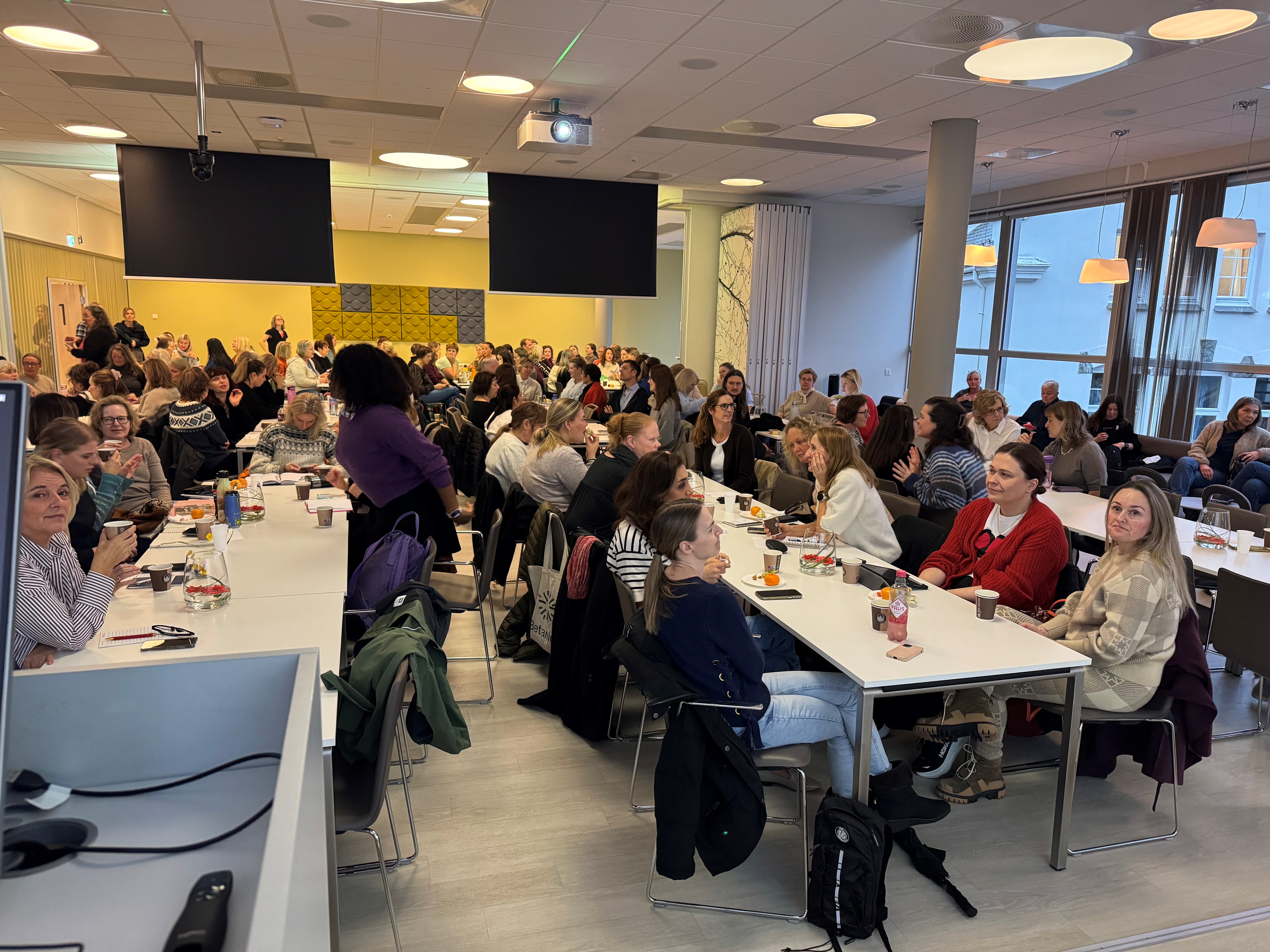 En gruppe mennesker som sitter ved bord