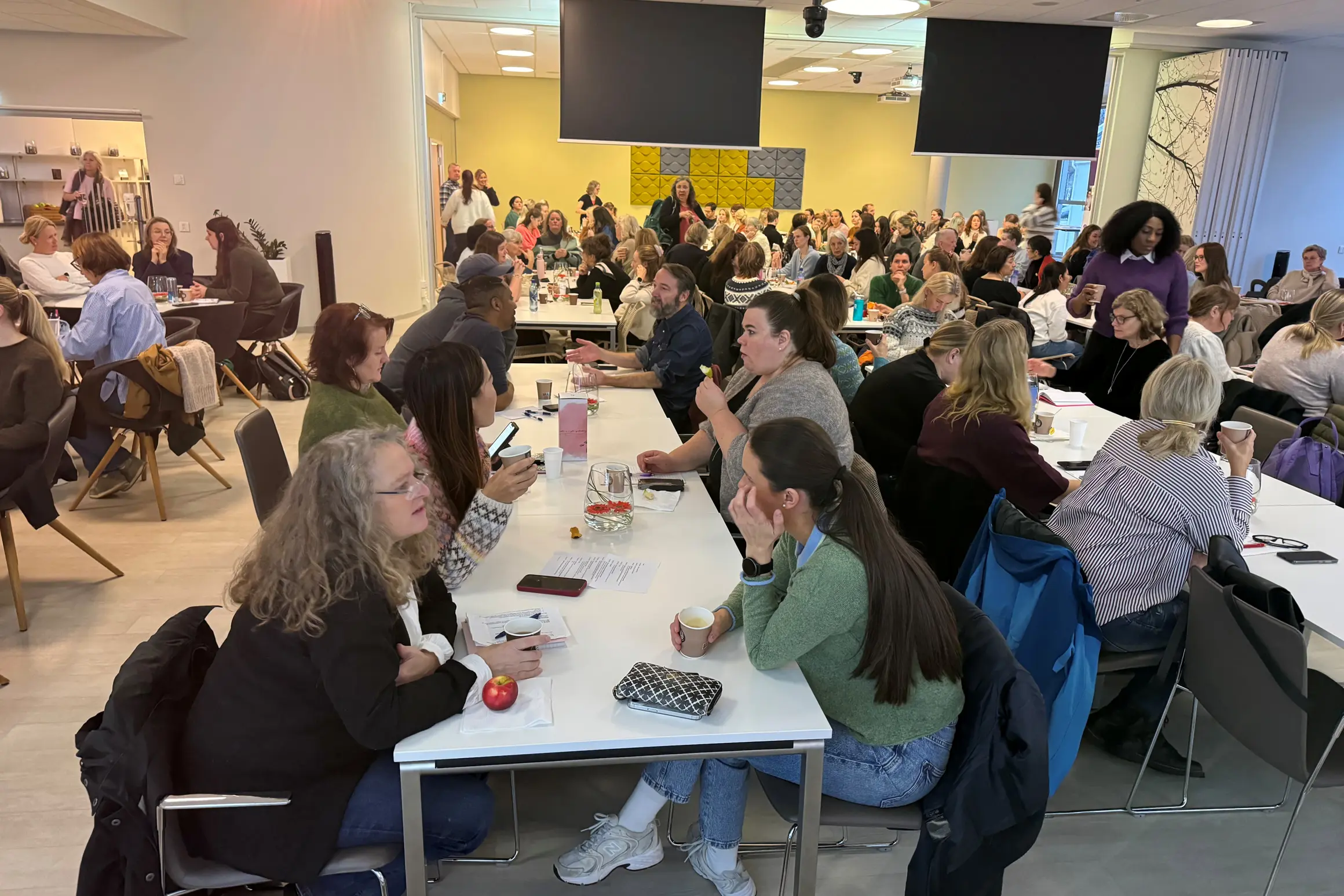 En gruppe mennesker som sitter ved bord