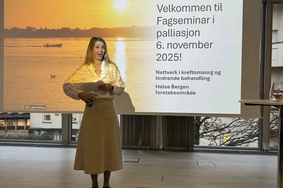 En person som står foran en stor skjerm