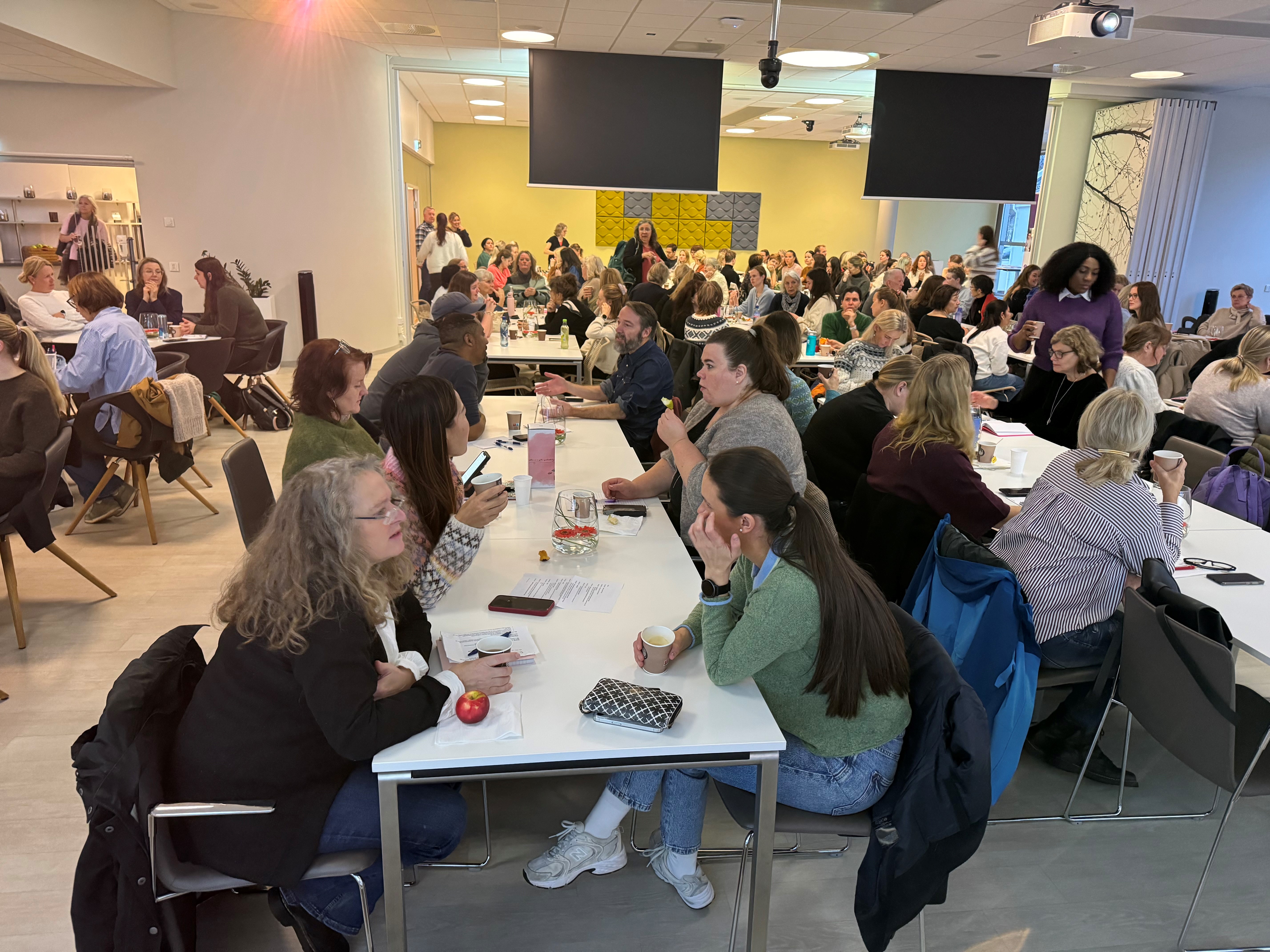 En gruppe mennesker som sitter ved bord